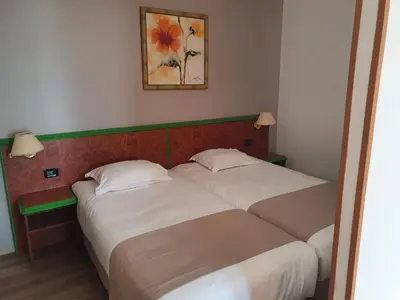 two beds in a hotel room with at Castel Vecchio in Ajaccio