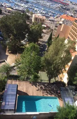 an overhead view of a pool with trees and a city at Castel Vecchio in Ajaccio
