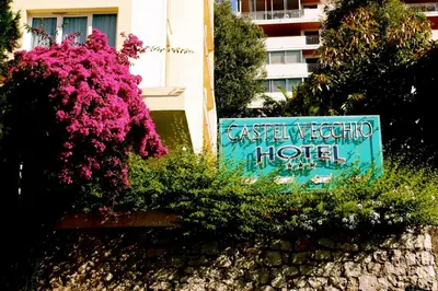 a hotel sign and flowers in front of a building at Castel Vecchio in Ajaccio