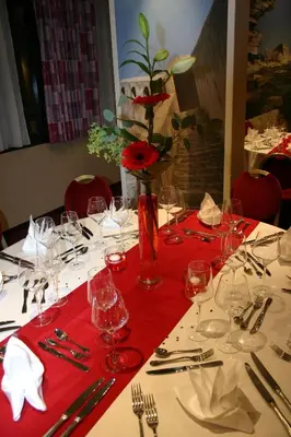 a table with a red table cloth and a vase with flowers at Castel Vecchio in Ajaccio