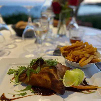 a plate of food with a fish and french fries at Hotel Le Ruesco in Olmeto