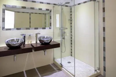 a bathroom with two sinks and a shower at Hotel Le Ruesco in Olmeto