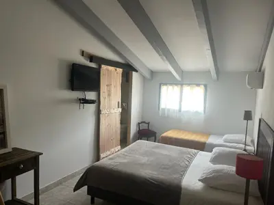 a bedroom with two beds and a flat screen tv at Auberge du col saint Georges in Grosseto-Prugna