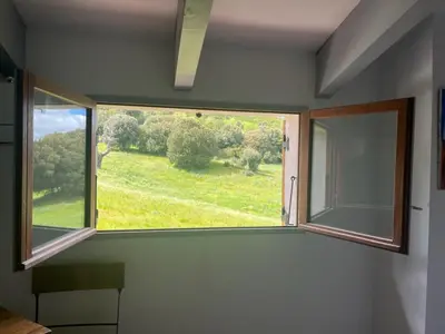 a window in a room with a view of a field at Auberge du col saint Georges in Grosseto-Prugna