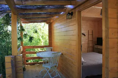 a room with a bed and a table in a cabin at Auberge U Sirenu in Sartène