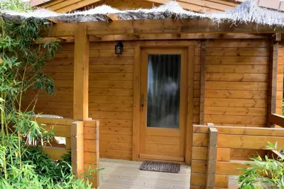a wooden shed with a door and a thatch roof at Auberge U Sirenu in Sartène