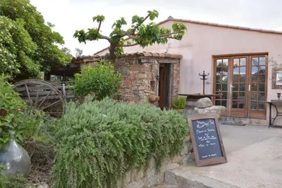a garden with a sign in front of a building at Auberge U Sirenu in Sartène