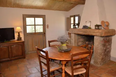 a dining room with a wooden table and a fireplace at Auberge U Sirenu in Sartène
