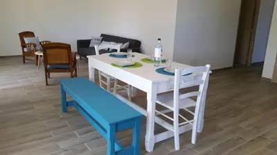 a white table and chairs with a blue bench at Villa E Lecce in Santa-Lucia-di-Moriani