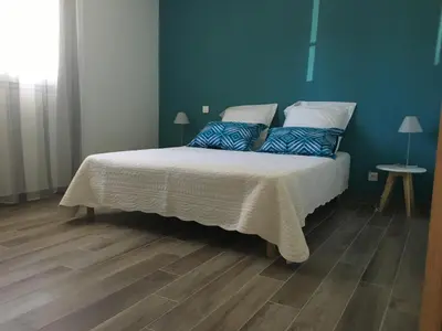 a bedroom with a large bed with blue walls at Villa E Lecce in Santa-Lucia-di-Moriani