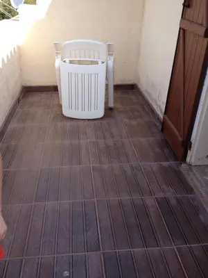a white chair sitting on a tiled floor at Mini-villa Vista bella in Porto-Vecchio