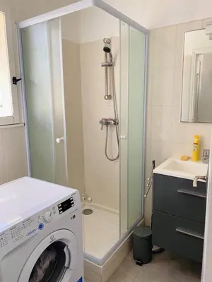 a bathroom with a shower and a washing machine at Mini-villa Vista bella in Porto-Vecchio