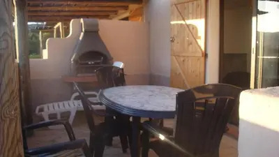 a table and chairs in a room with a stove at Mini-villa Vista bella in Porto-Vecchio