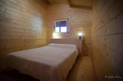 a small bedroom with a bed in a wooden cabin at Résidence Marina Livia in Serriera