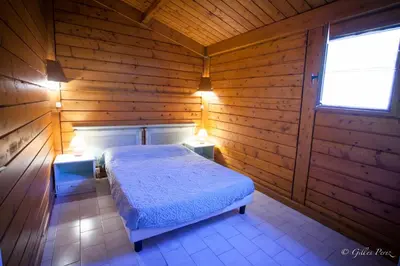 a bedroom with a bed in a wooden cabin at Résidence Marina Livia in Serriera
