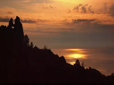 two people sitting on a hill at sunset at Résidence Marina Livia in Serriera