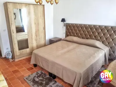 a bedroom with a large bed and a mirror at L'Escale in Bonifacio