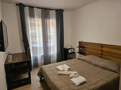 a room with a bed with towels and a television at L'Escale in Bonifacio