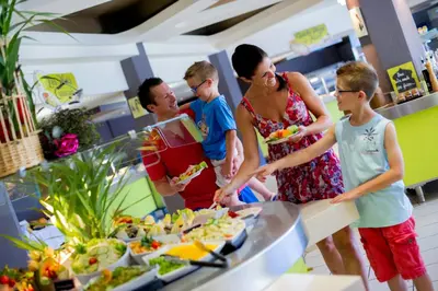 a group of people standing in front of a buffet at Le Village des Isles in Taglio-Isolaccio