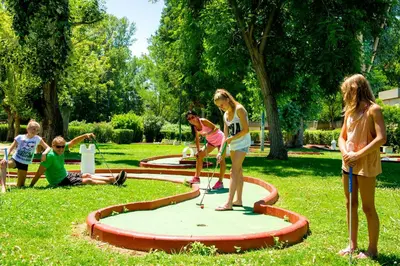 a group of girls playing golf in a park at Le Village des Isles in Taglio-Isolaccio