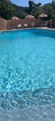 a large blue swimming pool with chairs and umbrellas at Residence 