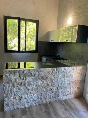 a kitchen with a stone counter and a window at Résidence U LATONU - Palombaggia in Porto-Vecchio