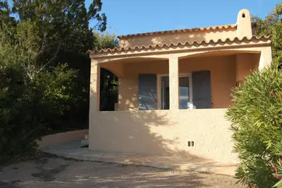 a small white house with a porch and trees at Résidence U LATONU - Palombaggia in Porto-Vecchio