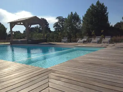 a swimming pool with a wooden deck and a gazebo at Cala Rossa Appart in Porto-Vecchio