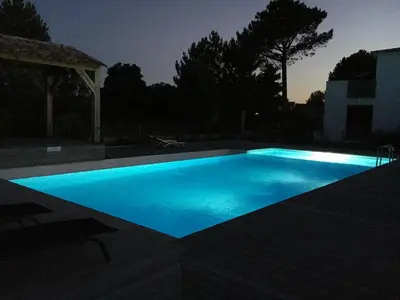 a swimming pool lit up at night at Cala Rossa Appart in Porto-Vecchio