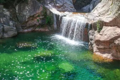 a waterfall in a pool of green water at Cala Rossa Appart in Porto-Vecchio