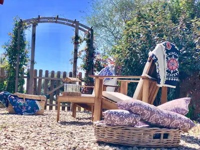 a wooden chair and a wicker basket in a backyard at Les Villas MarInCelu in Porto Pollo