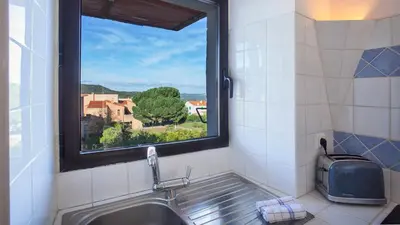 a kitchen with a sink and a window with a view at locations calenzana in Calenzana