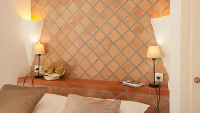 a room with a couch and two lamps on a wall at locations calenzana in Calenzana