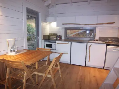 a kitchen with a wooden table and chairs at Albaria Lodge in Saint-Florent