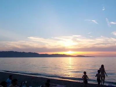 a group of people on the beach watching the sunset at Albaria Lodge in Saint-Florent