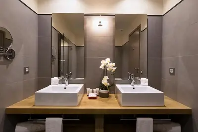 two sinks in a bathroom with two mirrors at Le Pinarello in Sainte-Lucie de Porto-Vecchio