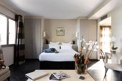 a hotel room with a bed and a table at Le Pinarello in Sainte-Lucie de Porto-Vecchio