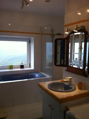 a bathroom with a sink and a tub and a window at indé no in Sari Solenzara