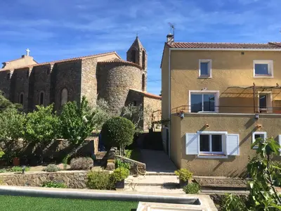 a building with a tower and a church at indé no in Sari Solenzara