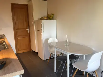 a small kitchen with a table and white refrigerator at Studio Pinzali Avec Mezzanine in Calenzana