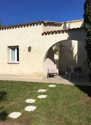 a house with a patio with a chair and a table at Studio Pinzali Avec Mezzanine in Calenzana