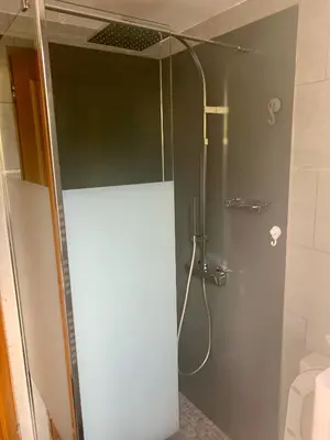 a shower with a glass door in a bathroom at Studio Pinzali Avec Mezzanine in Calenzana