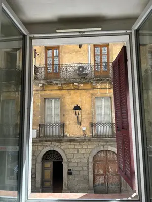 a reflection of a building in a glass window at T2 Sartène centre ville in Portigliolo