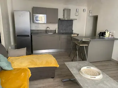 a living room with a couch with an orange blanket at T2 Sartène centre ville in Portigliolo