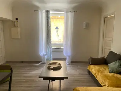 a living room with a couch and a table and a window at T2 Sartène centre ville in Portigliolo
