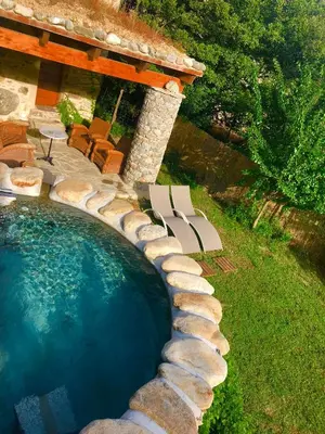 a swimming pool with chairs and a house at U Fragnu in Omessa
