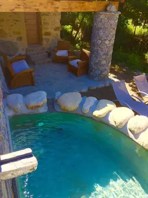 a pool of water with chairs and a patio at U Fragnu in Omessa