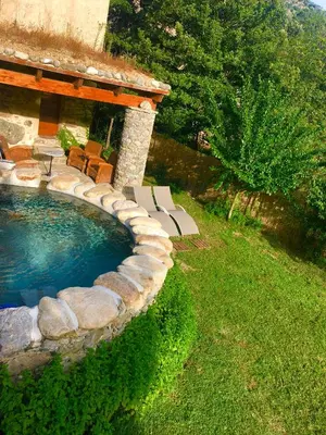 a swimming pool with chairs and a house at U Fragnu in Omessa