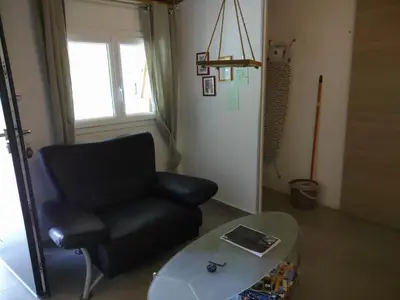 a living room with a black chair and a table at Maison Lisa Maria in Ponte-Leccia