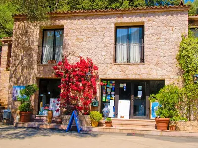 a building with red flowers in front of it at Camping Les Oliviers in Porto Ota
